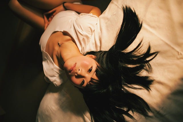 young asian model posing by the bed