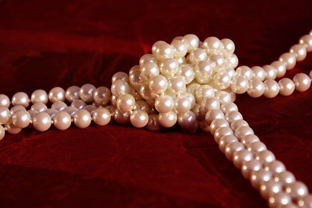 Knotted pearls on a background of red velvet