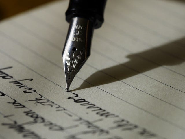 A fountain pen writing on a paper