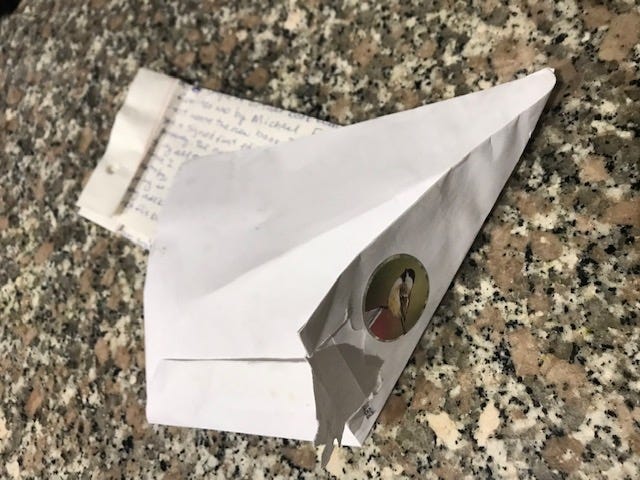 Partially folded envelope in front of folded letter.