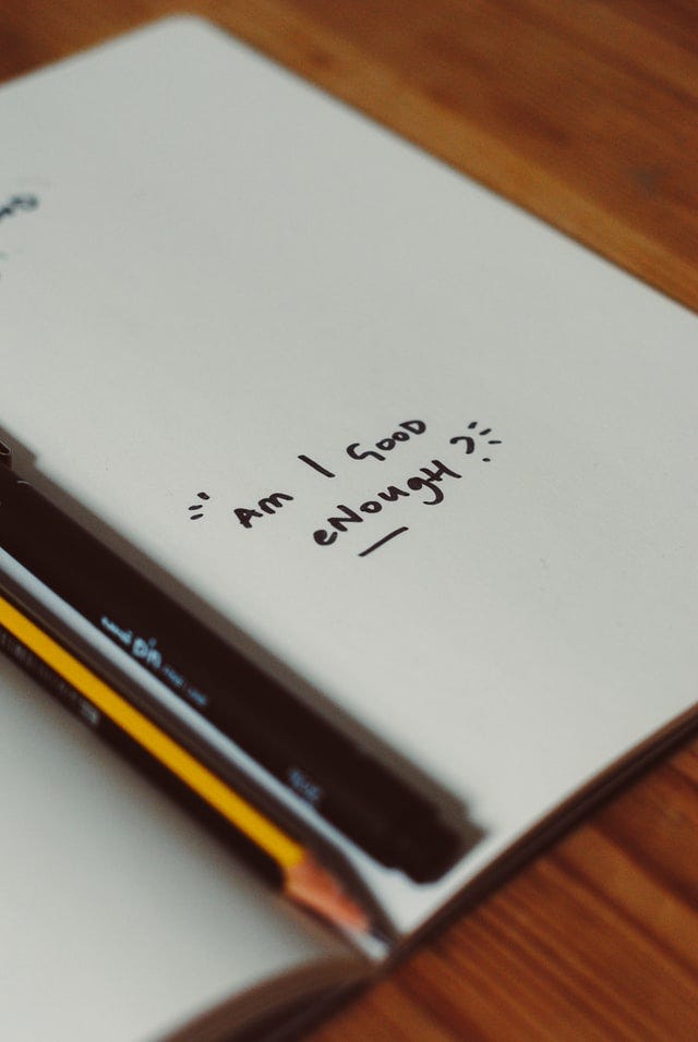 A white page says “Am I good enough?” written in black marker