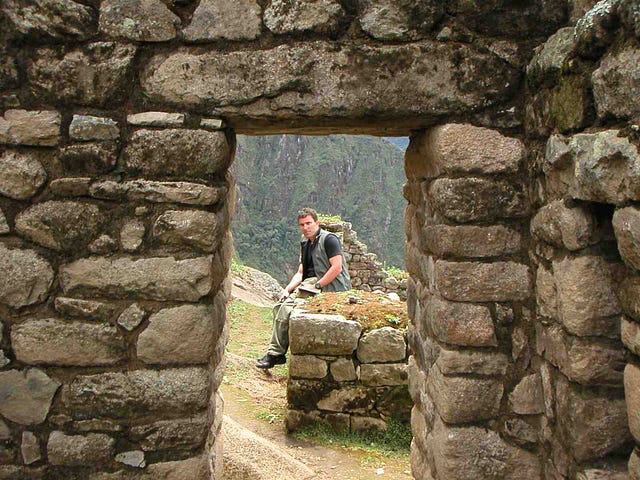 white guy sitting at Machu Picchu