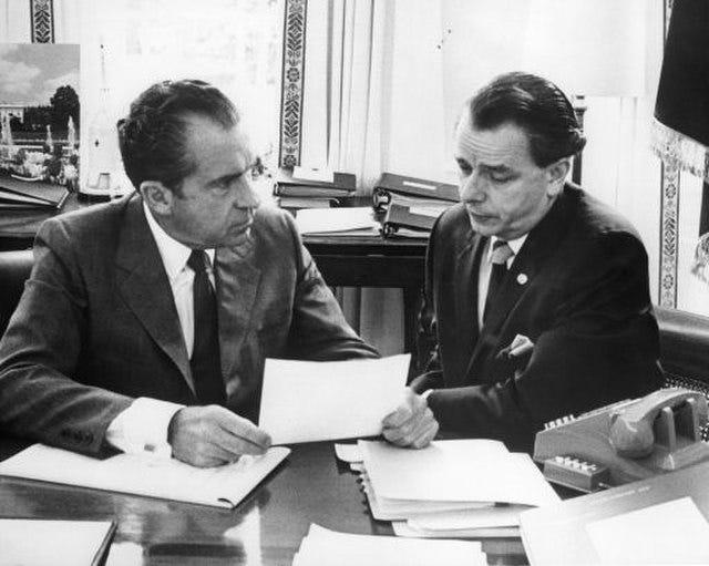 Two men seated side by side, Nixon on the left, Byrd on the right, examing a document. The picture is in black and white.