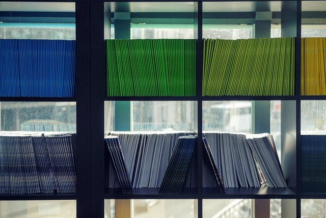 A number of notebooks neatly organized by color.