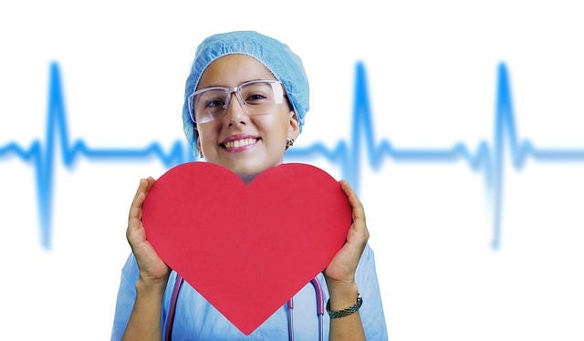 A nurse holding a big heart.