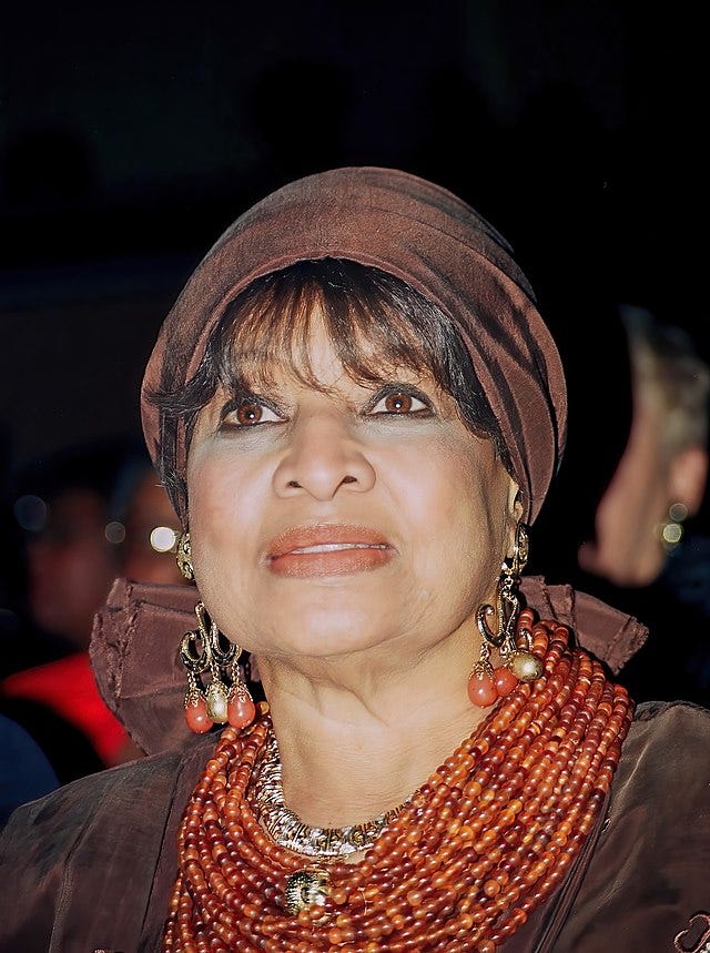 Civil rights activist Delores Tucker is pictured at a 1996 Washington D.C. Black caucus event. Tucker is wearing a brown head scarf, red lipstick and gold and red dangling earrings.