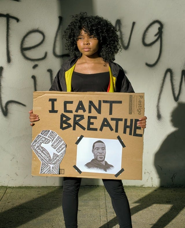 A protester in Washington DC holds a sign featuring George Floyd that says: “I can’t breathe”