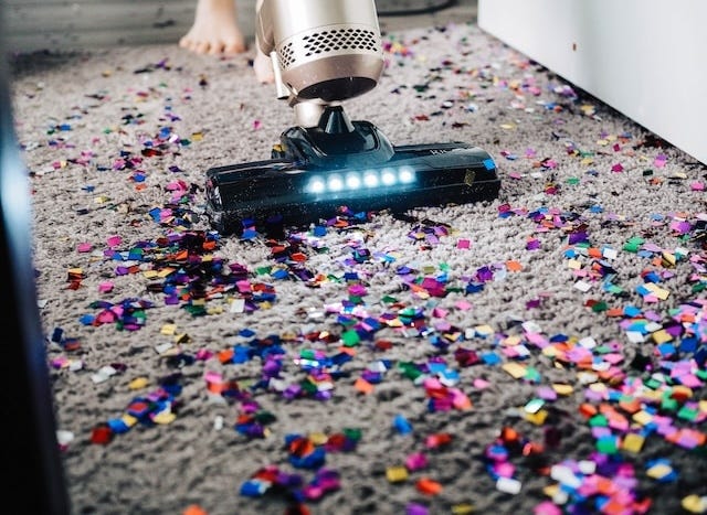 Vacuum cleaning up colourful confetti on a carpet