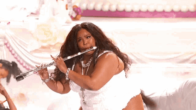 Gif of pop star Lizzo playing the flute (and being a boss whilst doing it)