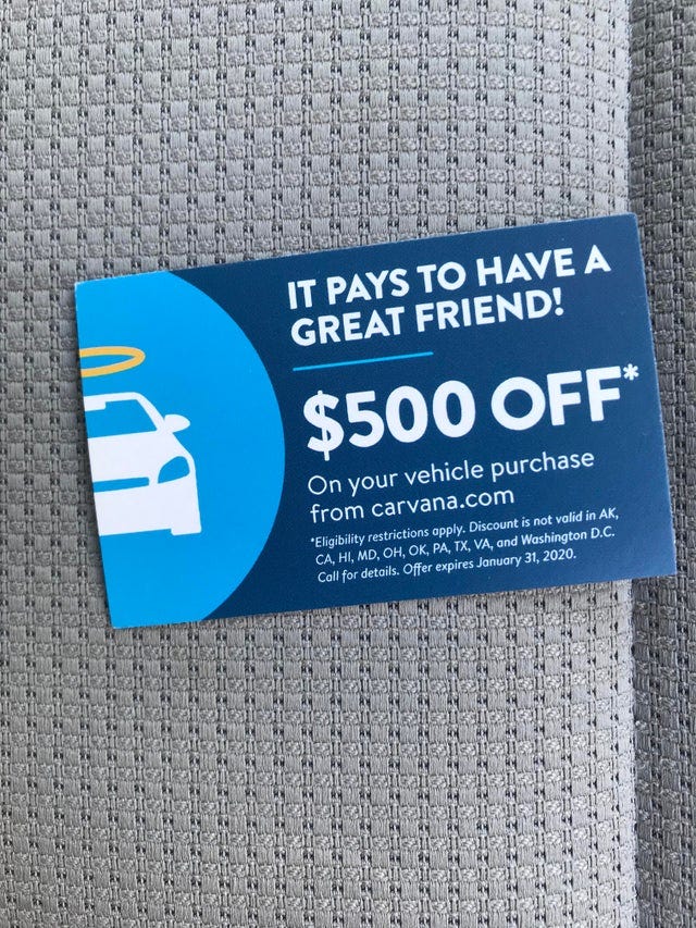 A dark blue card with a white car on the left hand side. It says five hundred dollars off on your vehicle purchase from Carvana.com