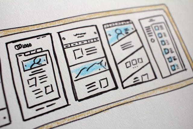 Esboços no papel de telas de um aplicativo móvel, representando o processo de prototipagem de um possível layout.