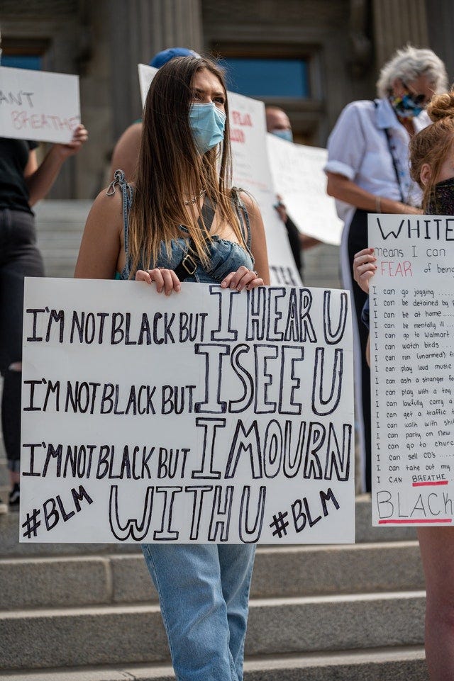 Protestor holding sign “I’m not black but I hear you, I’m not black but I see you, I’m not black but I mourn with you. #BLM”