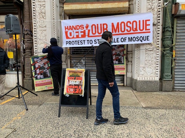 Rutgers School of Law-Newark student Saad Admani at a weekly Saturday protest in front of the mosque on Branford Pl, signage with white background and red writing “hands-off! our mosque — protest to stop the sale of the mosque”