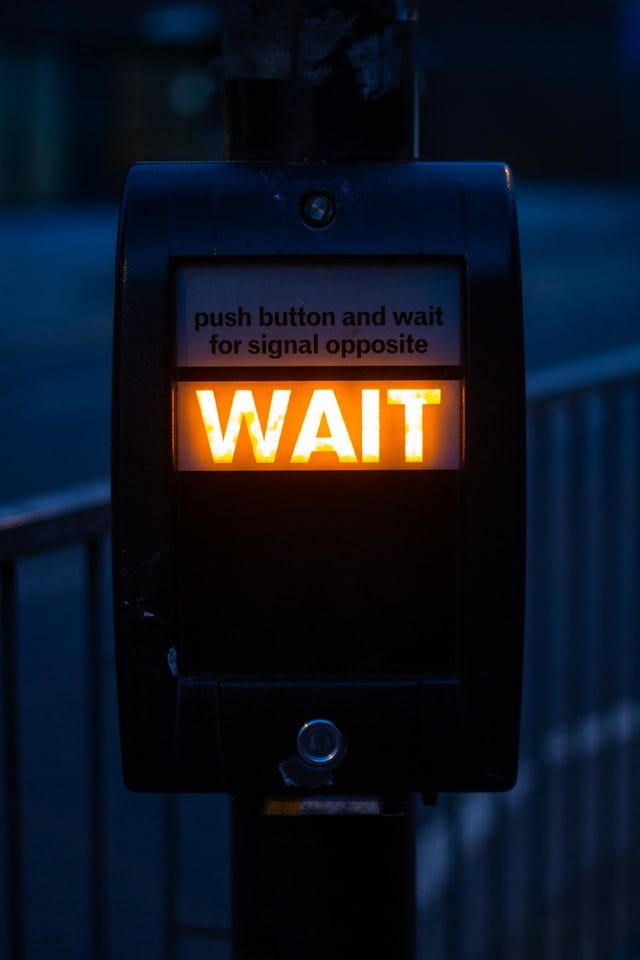 WAIT appears as a pedestrian illuminated sign
