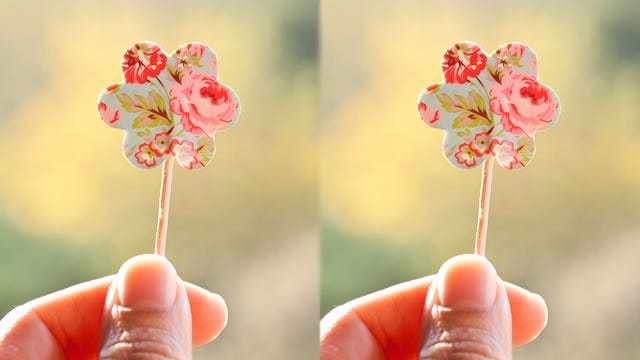 Two fingers holding paper flower X 2. (The image is doubled.)