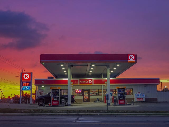 Photo of a Circle K glowing with the light of a beautiful sunset behind it