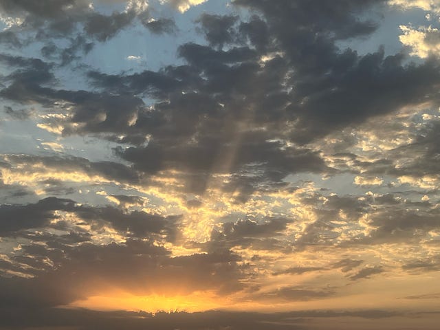 An orange sunset obscured by the clouds