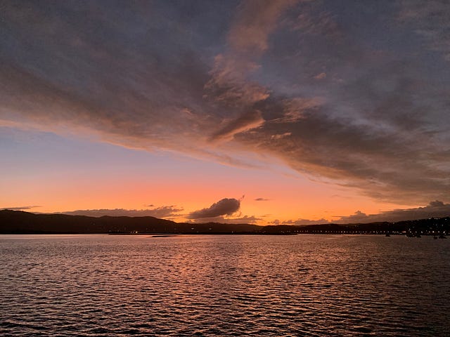 Sunset over a lake with large wispy clouds in the sky