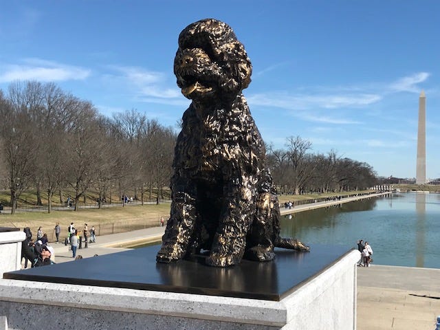 Statue of dog on a pedestal.