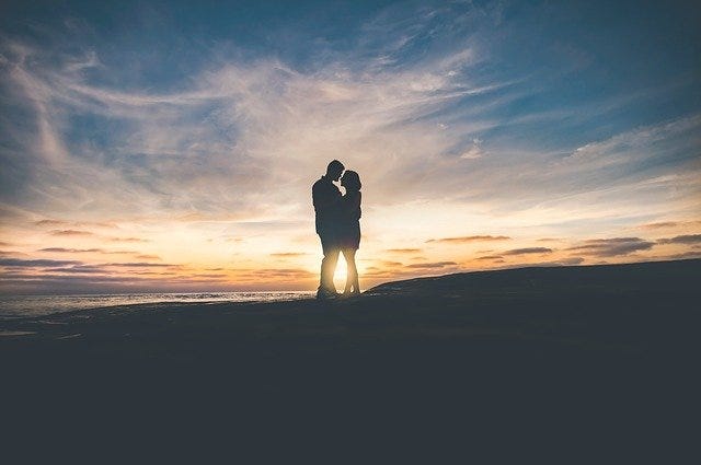 woman and man standing together at sunset