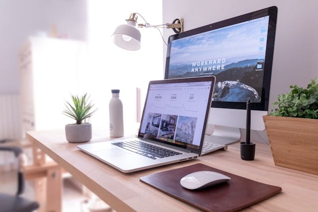 a laptop on a desk — screen says Work Hard Anywhere