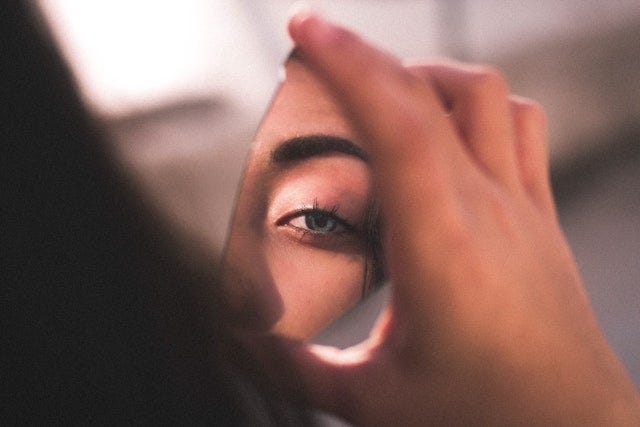 Mirror shard reflecting woman’s eye. Becka Lynn Rheumatoid Arthritis