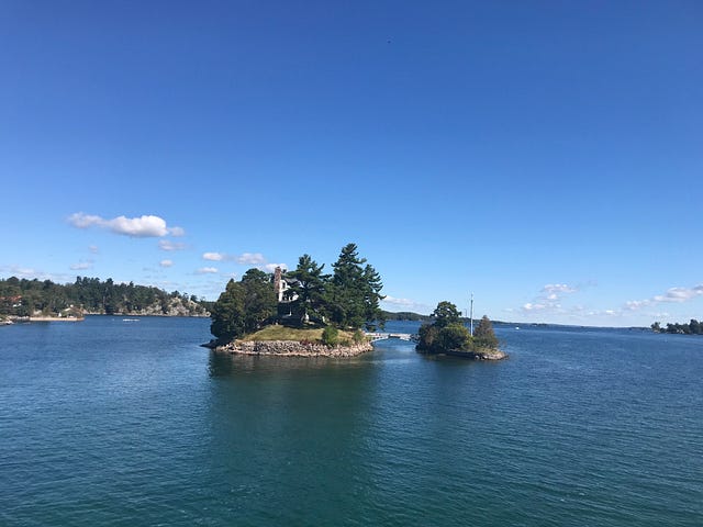 Photo of small island with house on it in the St. Lawrence River.