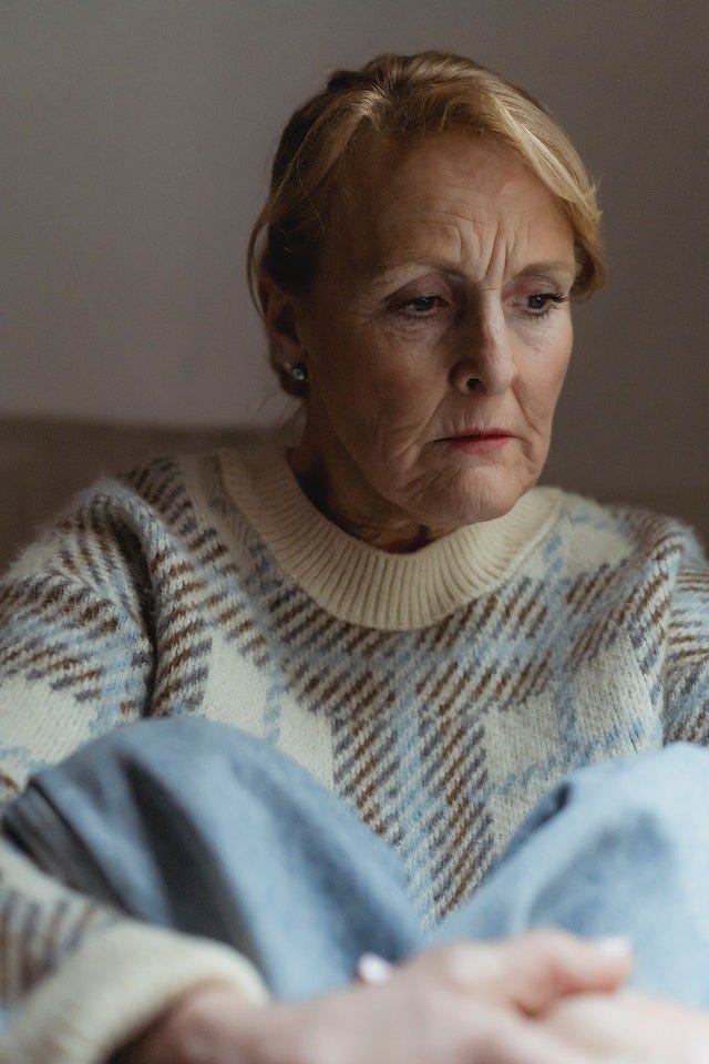 Older woman with a contemplative, worried look on her face.