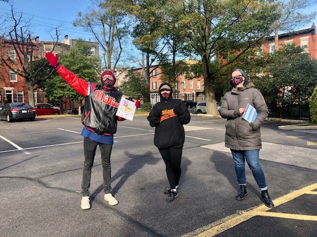 This is a picture of three Poll Greeter volunteers outside a polling place in Philadelphia, during a moment of calm after the morning rush.