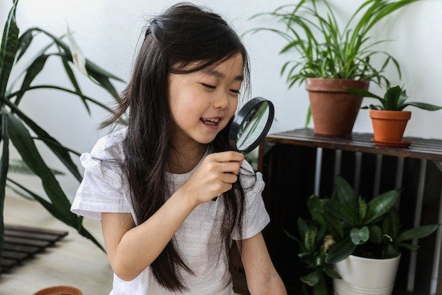Child holding magnifying glass to depict the curiousity of a child