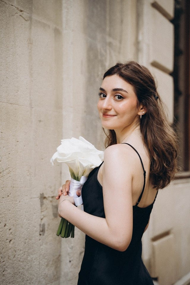 Photo by <a href=”https://unsplash.com/@seljansalim?utm_content=creditCopyText&utm_medium=referral&utm_source=unsplash">Seljan Salimova</a> on <a href=”https://unsplash.com/photos/a-woman-in-a-black-dress-holding-a-bouquet-of-flowers-rRUAnymVV0o?utm_content=creditCopyText&utm_medium=referral&utm_source=unsplash">Unsplash</a>