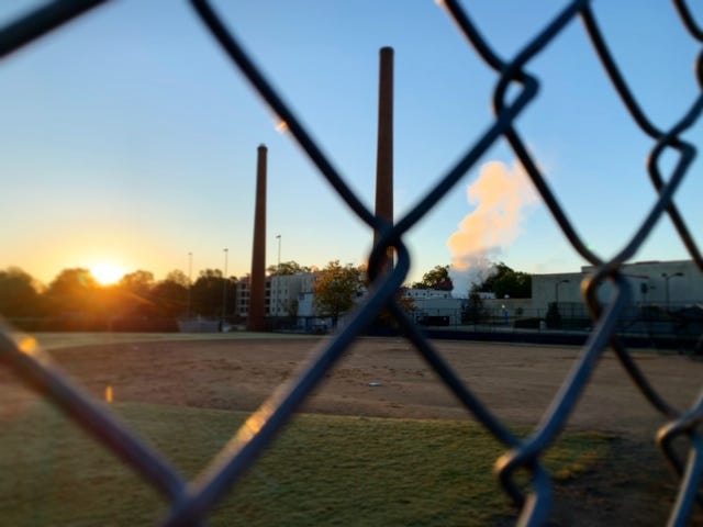 Industrial view through chain link fence sunrise