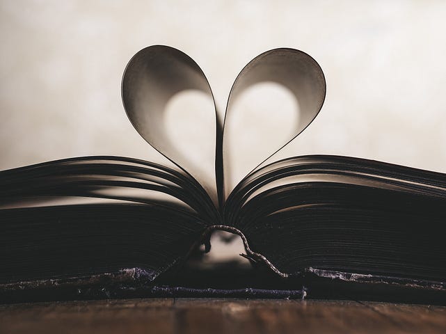 Open book with pages folded to form a heart.