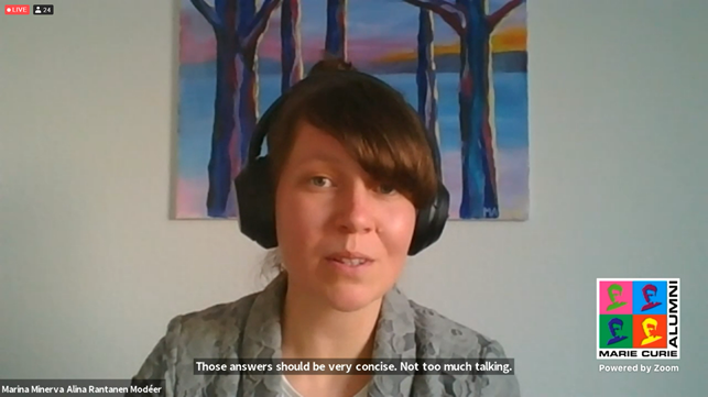 screenshot of Marina speaking. She is wearing a headset and has a painting of trees in the background