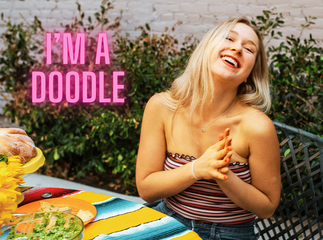 Beautiful blond in tube top laughing — written in pink on top “I’m a doodle”
