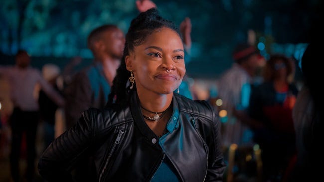 Woman smiling at a gathering. Character from a Netflix movie: A Soweto Love Story