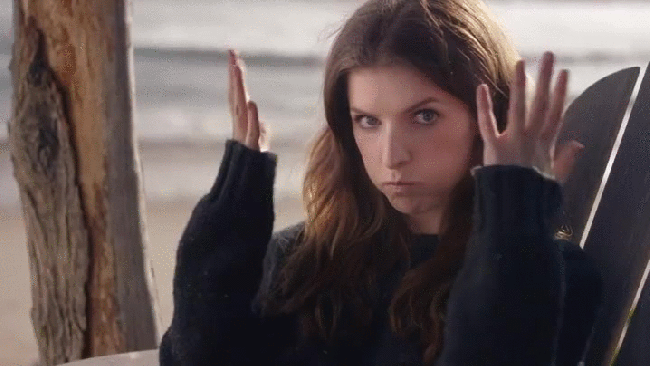 Anna Kendrink in a black sweater gesturing mind blown gif