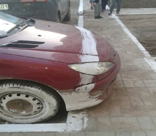 Crosswalk line painted across a car overhaning the paint way.