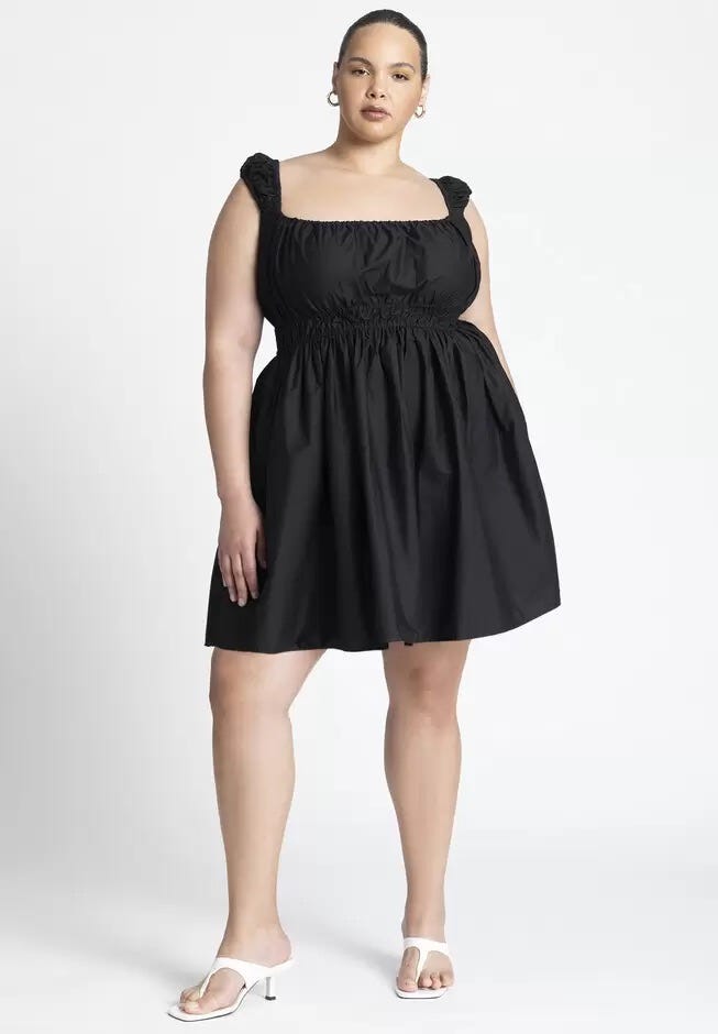 Model wearing a solid black, short, milkmaid style sundress.