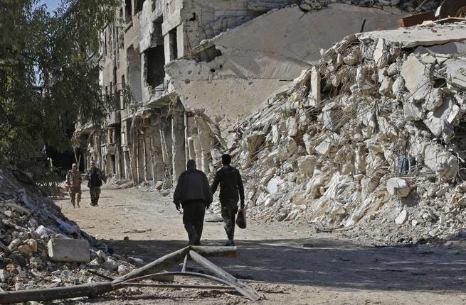 Varias personas caminan entre edificios destruidos del campo de refugiados palestinos de Yarmuk, al sur de Damasco, el 1 de noviembre de 2018. (Foto: Luai Beshara / AFP)