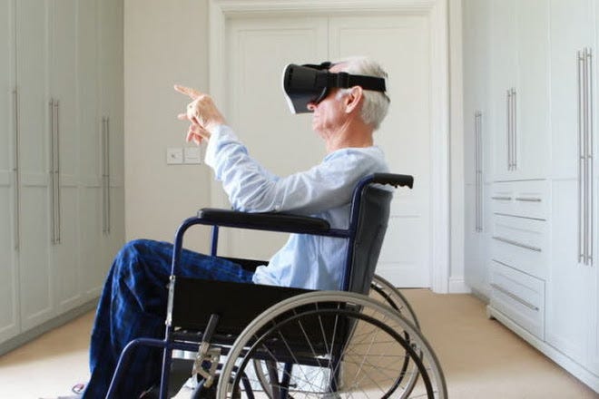 An elderly man in a wheelchair wearing virtual reality goggles.