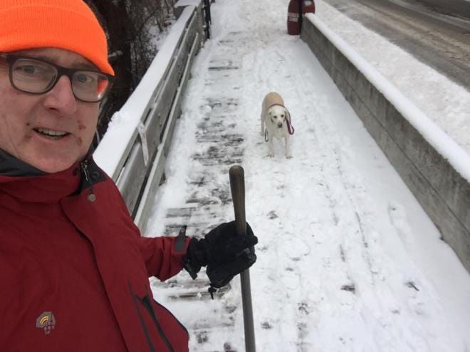 Bill Palladino on bridge with shovel and his dog, Tula.