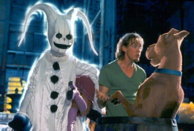 Image of Shaggy and Scooby, with a villain in a ghost costume behind them.