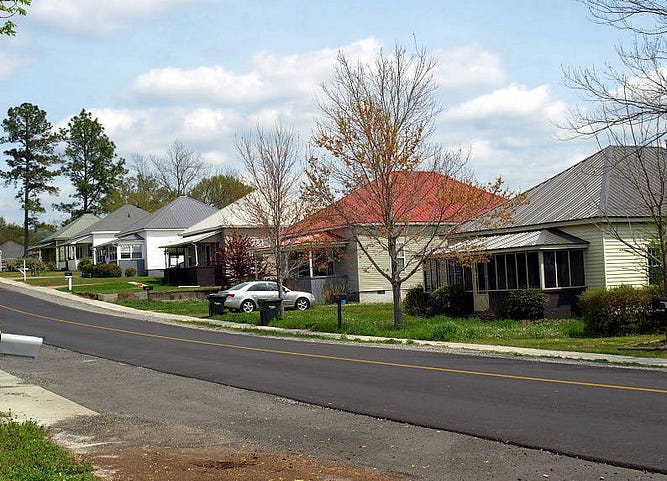 Updated Old Mill Village in Pell City, AL. Several small houses with the same framework in a row down a newly paved street.
