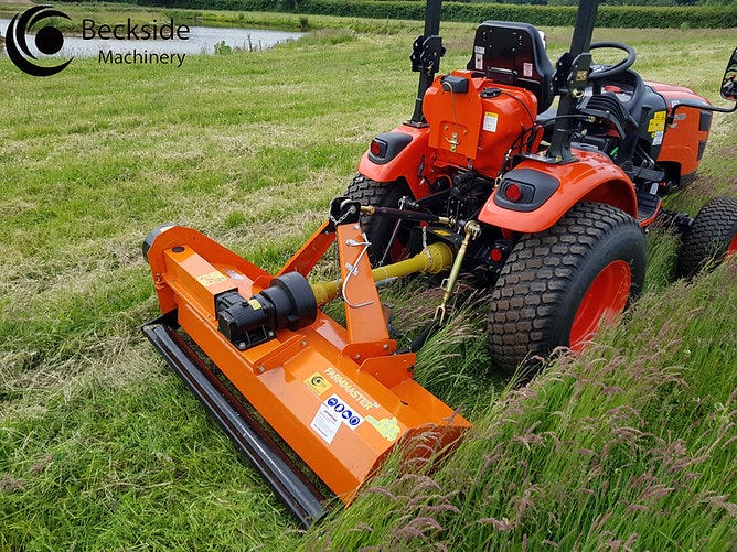 A Farm Master flail mower being pulled by a compact tractor while mowing a green field