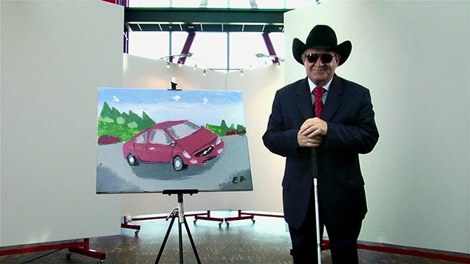 Esref Armigan, a Turkish painter who experiences blindness, with a painting he made as part of a Volvo marketing campaign.