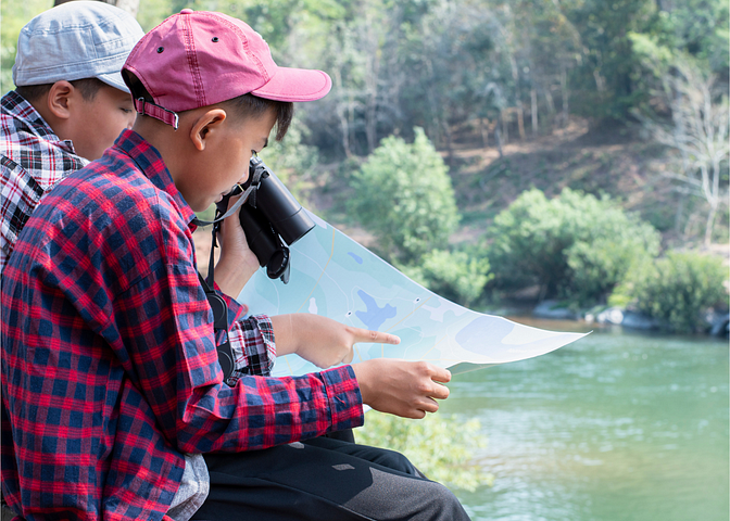 Two boy reading a map together