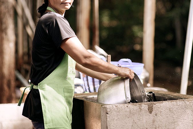 Pekerja migran perempuan di Thailand sedang mencuci panci. A woman migrant worker washes pots in Bangkok, Thailand