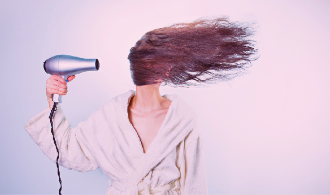 woman blowing long hair with hair dryer