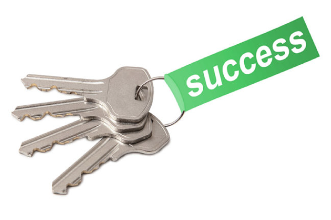 A picture of four keys on a keyring with a tag attached that says “success” on it.